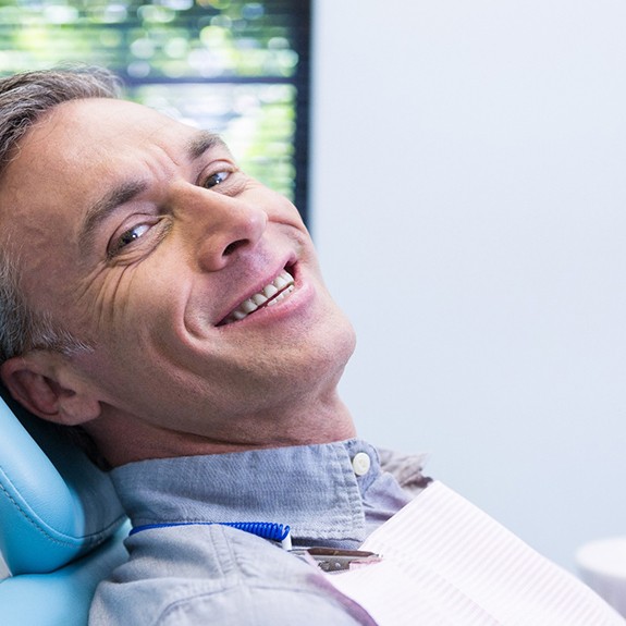 Older man smiling while waiting for dentist