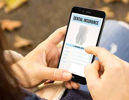 A woman looking at a dental insurance form on her phone