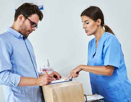 A man with glasses paying the cost of Invisalign