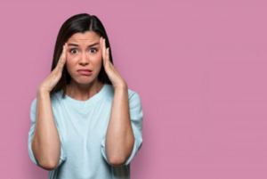 Woman rubbing her temples and looking stressed